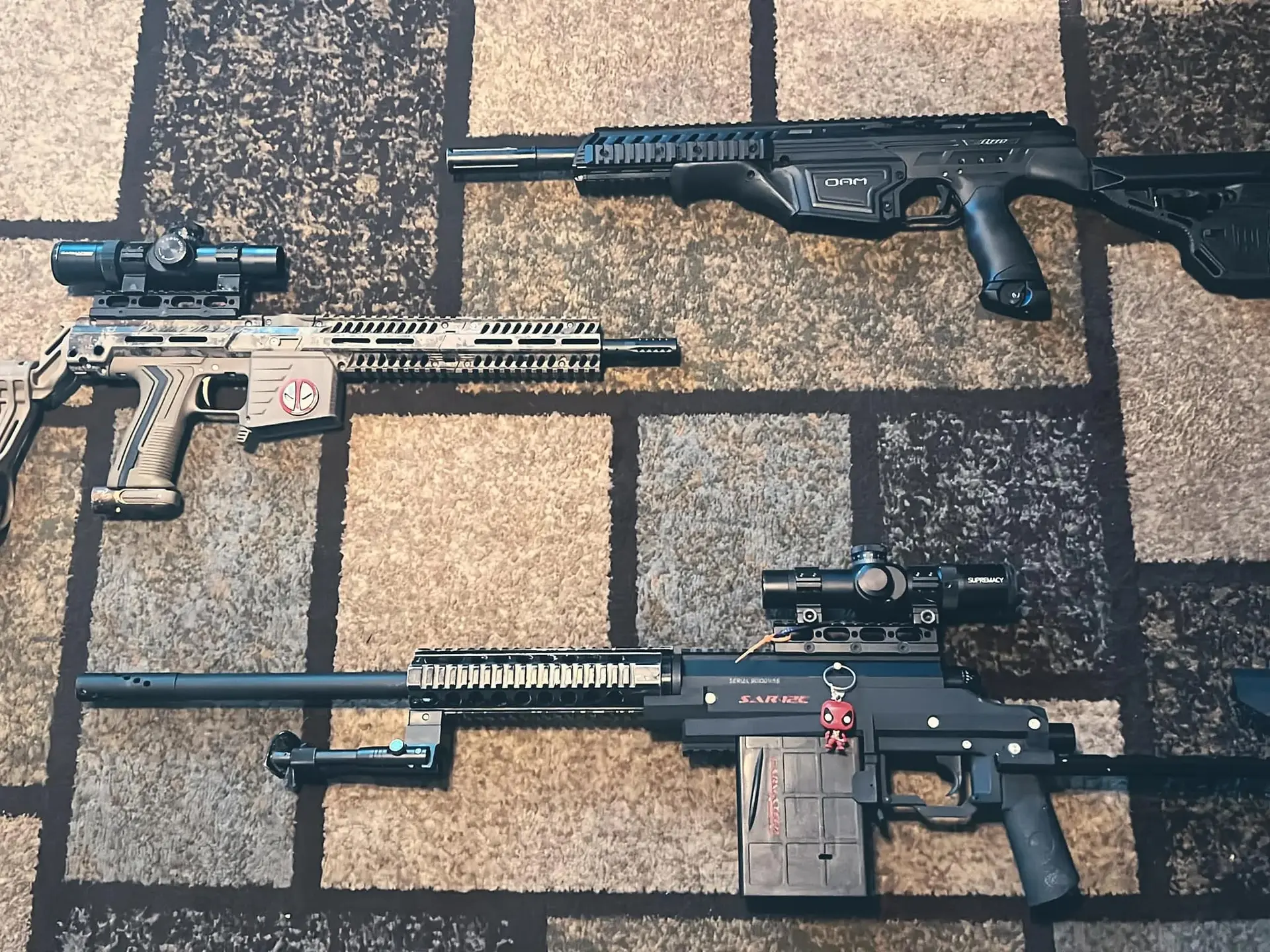 Different magfed paintball markers laid out for comparison
